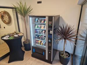 a soda vending machine in a room with potted plants at Steirermaxx Apartments in Gaal