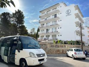biały autobus zaparkowany przed budynkiem w obiekcie Hotel Selva Arenal w El Arenal