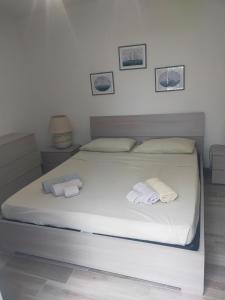 a large white bed with two towels on it at La Dependance in Centro in Follonica
