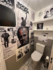 a bathroom with a toilet and posters on the wall at Loft HATISAS in Brides-les-Bains