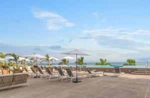 a group of chairs and umbrellas on a patio at Zantamar - Beachfront Suites in La Cruz in Cruz de Huanacaxtle