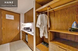 a small kitchen with wooden cabinets and a refrigerator at S79 Residences LYN Panorama Suite in Nha Trang