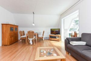 a living room with a couch and a table at Ferienhaus Boje 13 in Neuharlingersiel