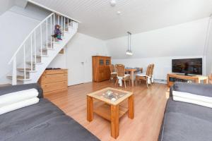 a living room with a couch and a table at Ferienhaus Boje 13 in Neuharlingersiel