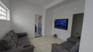 a living room with two couches and a flat screen tv at Casa térrea no centro ideal para famílias e trabalho in Mogi das Cruzes