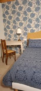 a bedroom with a bed and a table and a chair at Casa Elisa affittacamere in Armeno