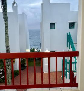a red railing with the ocean in the background at 31 Akrotiri, Santorini, Ballito in Ballito +8 photos