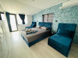 a blue bedroom with a bed and a couch at Neversea Boutique Villa in Constanţa
