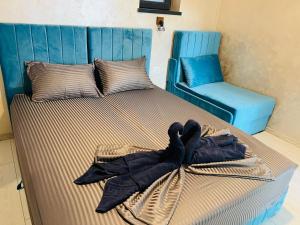 a bed with a blue headboard and a chair at Neversea Boutique Villa in Constanţa