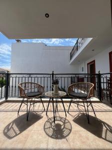 a patio with two chairs and a table on a balcony at Pantheon in Skiathos Town