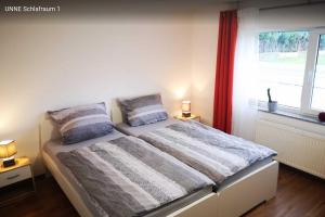 a bedroom with a bed with two pillows and a window at Haus Birkenblick in Rimbach