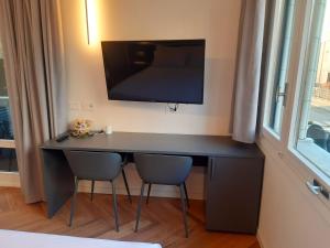 モンツァにあるMako Suites - Centro e Stazioneのデスク(椅子2脚付)、壁掛けテレビ