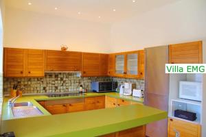 une cuisine avec des armoires en bois et un comptoir vert dans l'établissement Ferienhaus Landhaus EMG Kempen, in Alleinlage nahe Düsseldorf und Venlo, à Tönisvorst