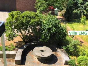 un banc en pierre dans un jardin avec un bush dans l'établissement Ferienhaus Landhaus EMG Kempen, in Alleinlage nahe Düsseldorf und Venlo, à Tönisvorst