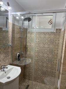 a bathroom with a sink and a glass shower at Studio Central PCS in Bucharest +4 photos
