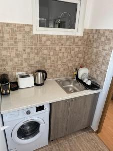 a kitchen with a sink and a washing machine at Studio Central PCS in Bucharest