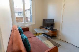 a living room with a couch and a table at Baignoire balnéo avec climatisation in Saint-Étienne +26 photos
