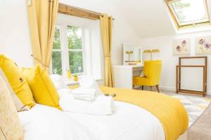 a bedroom with a large white bed with yellow pillows at Luxury -chelt Walking-2bed-long Stays-parking in Cheltenham