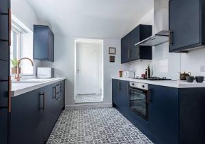 une cuisine avec des armoires bleues et un évier blanc dans l'établissement Sedgley-wolverhampton-contractors -4 Beds-parking, à Sedgley