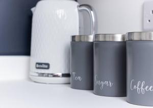 une rangée de tasses à café assises sur un comptoir dans l'établissement Sedgley-wolverhampton-contractors -4 Beds-parking, à Sedgley 16 autres photos