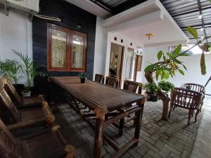a dining room with a wooden table and chairs at M2 Homestay Jogja in Jarakan