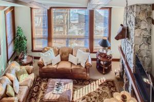 ein Wohnzimmer mit einem Ledersofa und einem Kamin in der Unterkunft Stonegate Resort Unit A403 in Kelowna