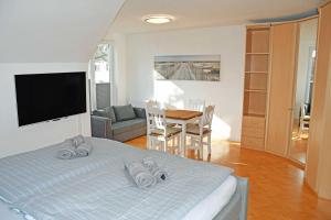 ein Schlafzimmer mit einem Bett und einem Tisch und einem Fernseher in der Unterkunft schöne Ferienwohnungen in Dranske auf dem Windland in Dranske