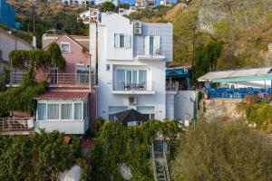 a white house on the side of a hill at Ammoudeli Apartments - Beachfront Apartments in Plomari in Plomari