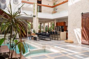 Una sala de estar con piscina y una casa. en Villa Tikal, en Tulum