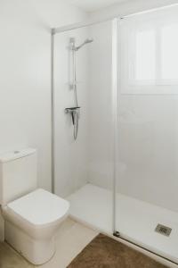 a white bathroom with a toilet and a shower at Casa Bahía in El Puerto de Santa María +19 photos