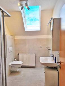 ein Badezimmer mit Waschbecken und Toilette und einem Fenster in der Unterkunft schöne Ferienwohnungen in Dranske auf dem Windland in Dranske + 49 Fotos
