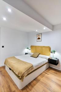 a bedroom with a large bed in a white room at Apartamentos Beatriz by gaiarooms in Salamanca