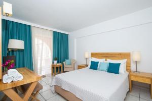 a bedroom with a bed and a table with towels at Bitzaro Palace Hotel in Kalamaki