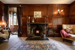 Elle comprend un salon doté d'une cheminée et de murs en bois. dans l'établissement Large Grade II Listed House & Garden nr Beaches, à Saint Columb Major
