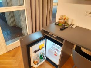 モンツァにあるMako Suites - Centro e Stazioneの小型冷蔵庫(テーブルの横にドアを開けます)
