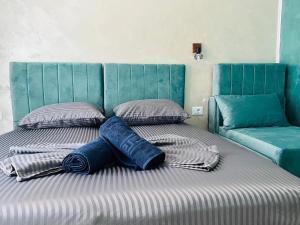 a bed with two pillows and a blue head board at Valy Boutique in Constanţa