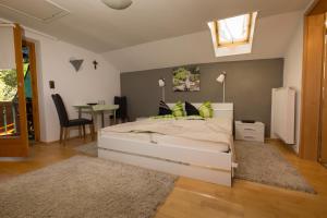 1 dormitorio con cama blanca y almohadas verdes en Frühstückspension Mayer-Schiller, en Bernried