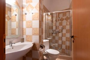 a bathroom with a toilet and a sink and a shower at Ammoudeli Apartments - Beachfront Apartments in Plomari in Plomari +89 photos