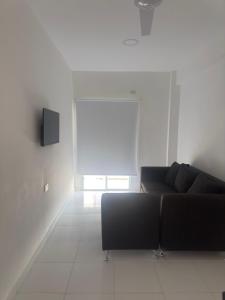 a living room with a black couch and a window at Edificio Luggren in Formosa
