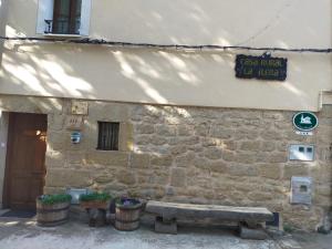 a stone building with a bench in front of it at Casa la ilera in Casalarreina