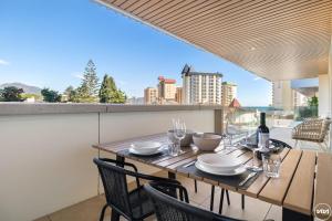 a table with chairs and a bottle of wine on a balcony at ViVi Homes - Jade Beautiful Apartment with Spa, Pool and Cinema 200 meters from the beach in Fuengirola