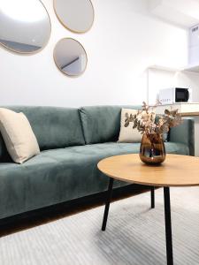 a living room with a green couch and a table at Apartman COMO, private parking free in Košice