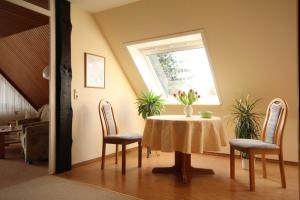 a dining room with a table and chairs and a window at Ferienwohnungen Roeper in Bad Bevensen