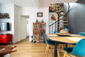 a dining room with a table and blue chairs at Les Fauvelles Paris La Défense in Courbevoie
