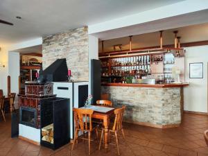 a kitchen with a stove and a table and a bar at Restaurace Penzion Na Poště in Strašice