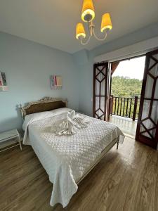 Un dormitorio con una cama blanca y una ventana grande. en Apartamento Rosa en Castelo para Familia, en Campos do Jordão 58 fotos más