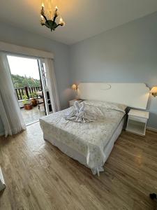 Un dormitorio con una cama y una ventana grande. en Apartamento Rosa en Castelo para Familia, en Campos do Jordão