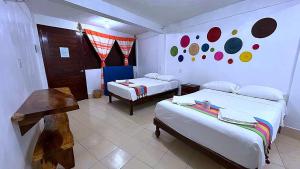 een kamer met twee bedden en een bank erin bij Hotel Casa del Mar Mazunte in Santa María Tonameca