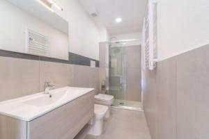 Un baño con lavabo, inodoro y ducha. en La Stampa Room, en Olbia
