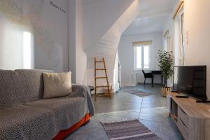 a living room with a couch and a tv at Green House - Central Stay in Plomari in Plomari